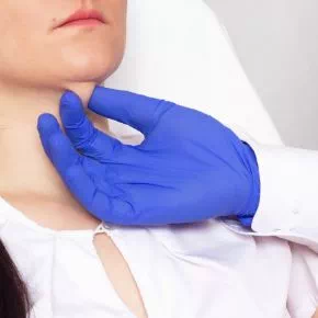 lekarska dłoń dotykająca szyi pacjentki